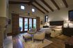 Une grande chambre avec poutres au plafond de bois.