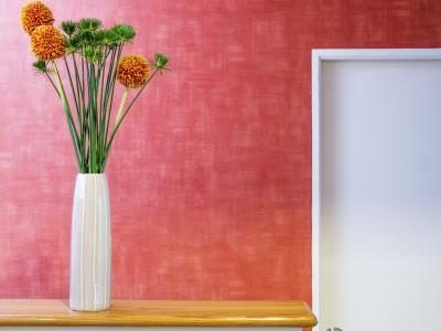 Fleurs dans un vase en hauteur sur une étagère remplir l'espace mural généreuse.