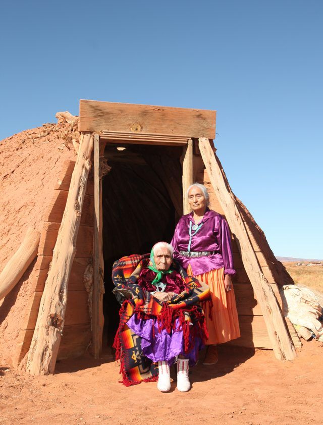 Deux femmes âgées Navajo en dehors de l'entrée d'une hutte