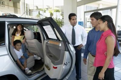 Vendeur voiture montrant aux clients à un concessionnaire automobile.