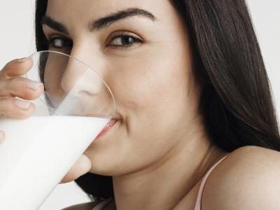 Une femme boit un verre de lait.