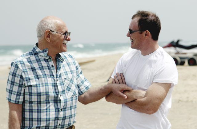 Un père et son fils ont une conversation sur une plage.