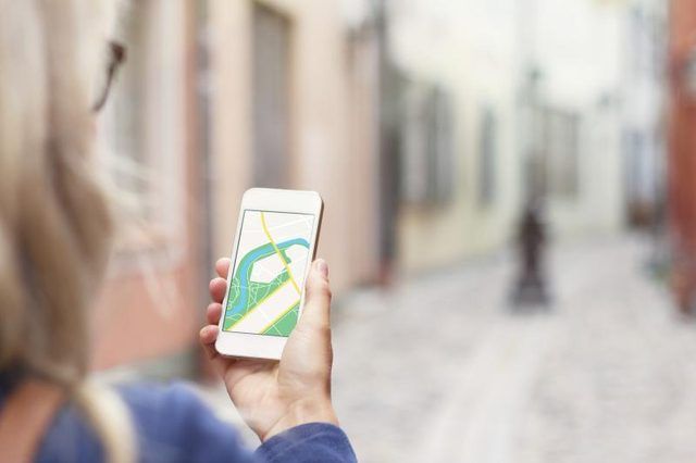 Un touriste en utilisant le GPS sur son téléphone intelligent tout en marchant.