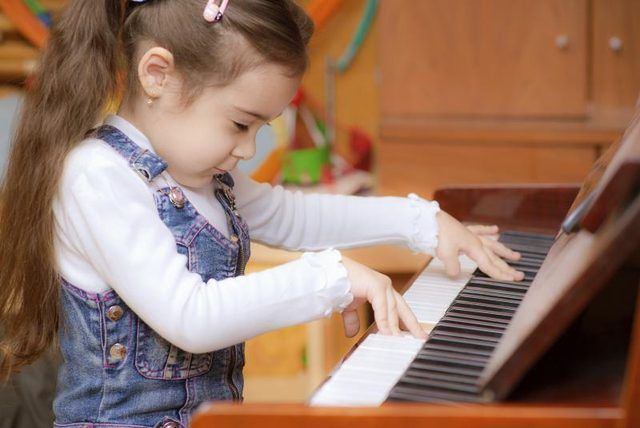 Bambin jouant sur petit piano.