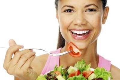 Lifestyle photo de femme souriante et manger de la salade.