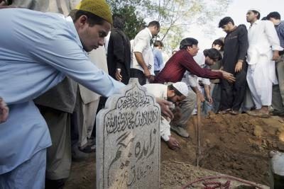 Lancer la saleté sur une tombe peut symboliser un profond respect et de la coutume religieuse.