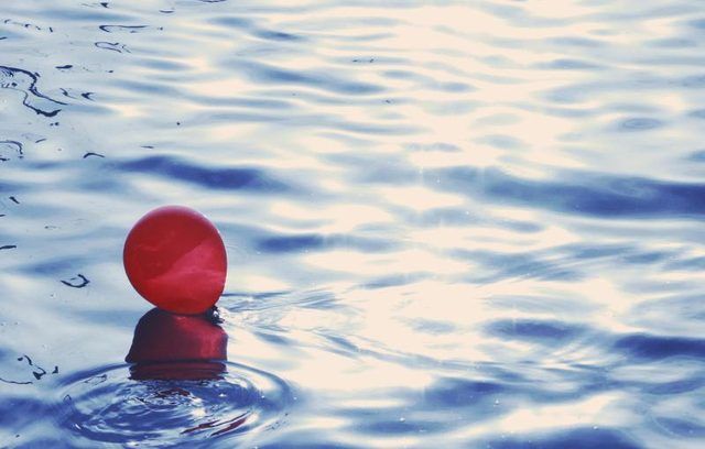 Un ballon rouge flottant sur l'eau.