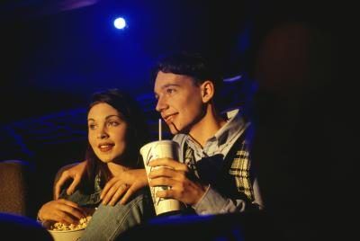 Un partage d'un verre dans une salle de cinéma jeune couple.
